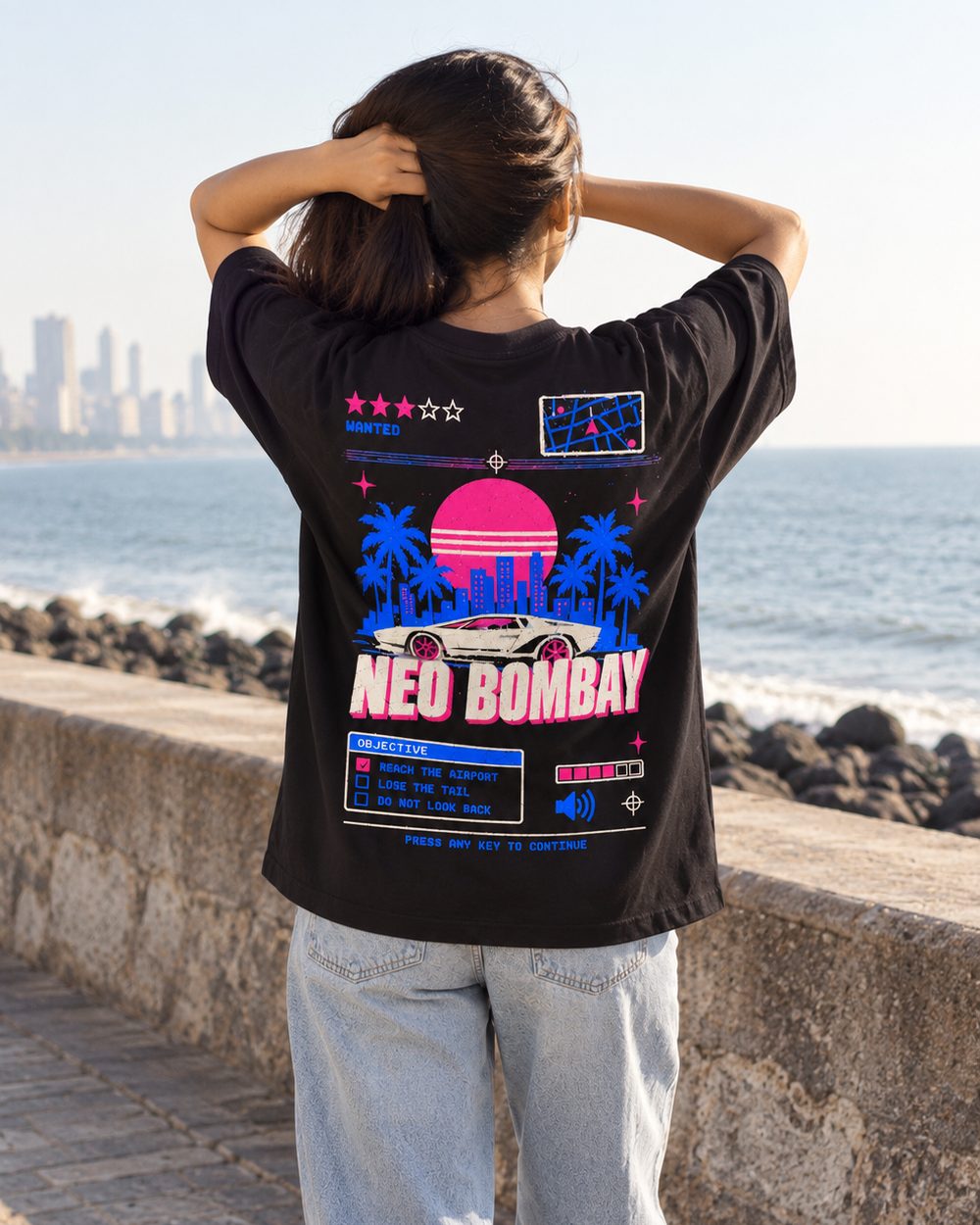 Neo Bombay tee, full back print, hands behind the head on the promenade