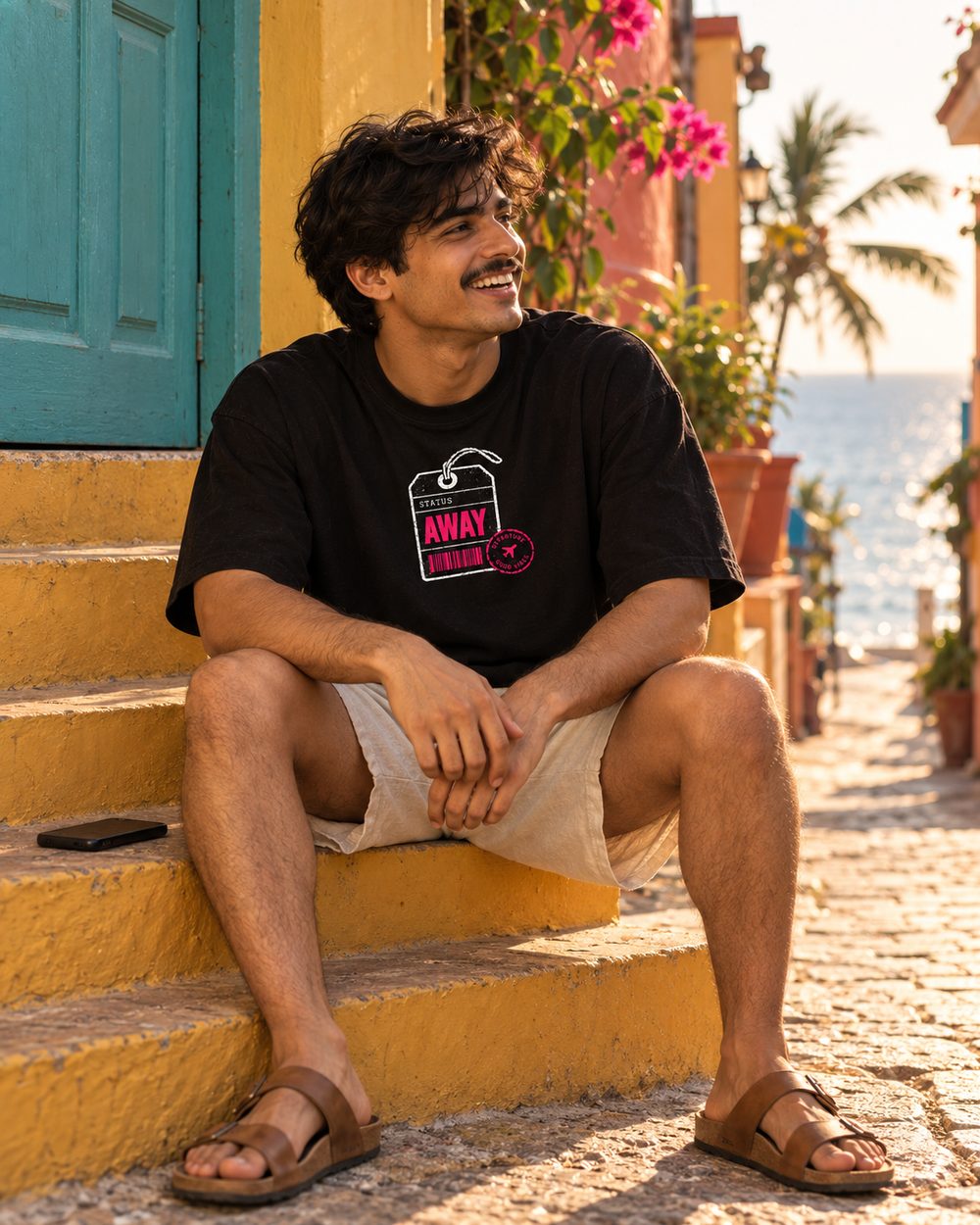 Out of Office tee, AWAY tag chest print, sitting on yellow steps